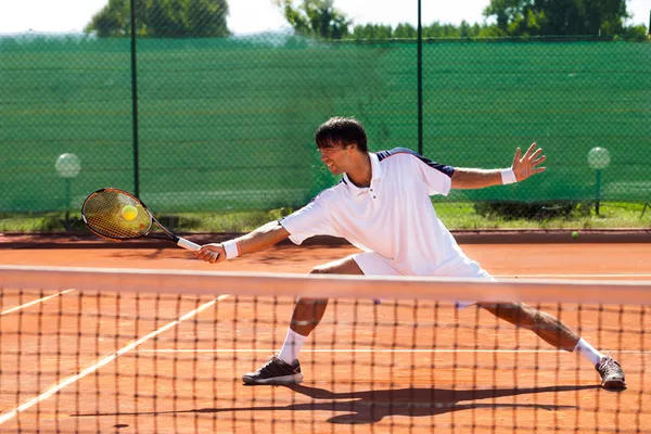 Молодой человек, играющий в теннис — стоковое фото
