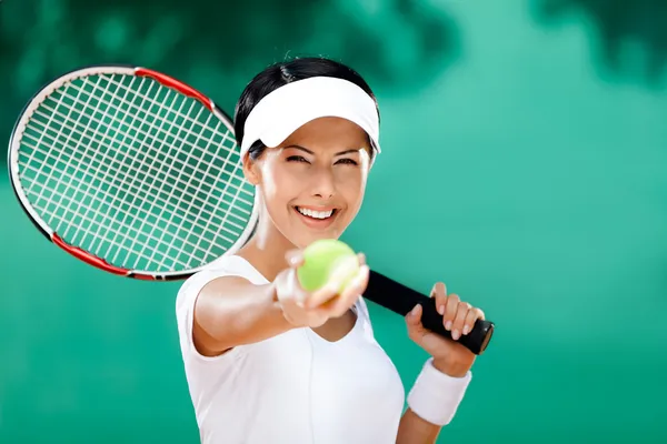 Спортивный женщина служит теннисный мяч — стоковое фото