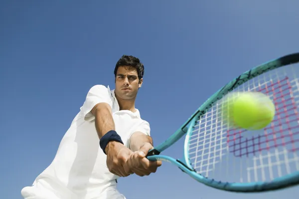 Теннисный игрок ударяя мяч — стоковое фото