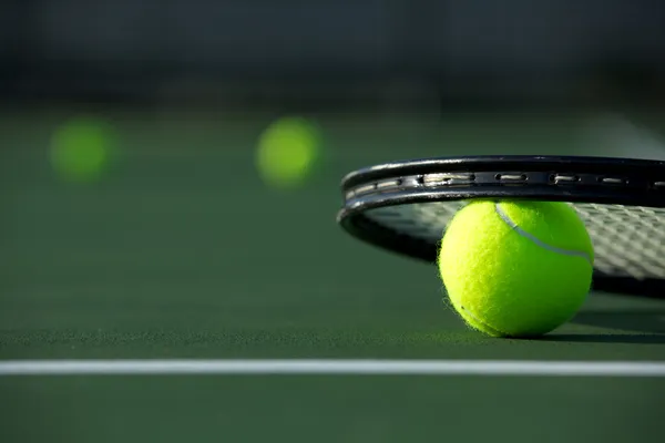 Теннисные шары и ракетка — стоковое фото