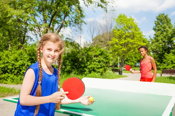 Две Счастливые девушки, игра пинг-понг вне — стоковое фото