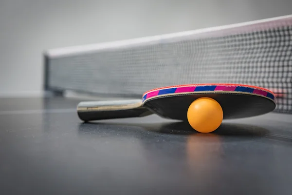 Настольный теннис ракетки с оранжевый шар — стоковое фото