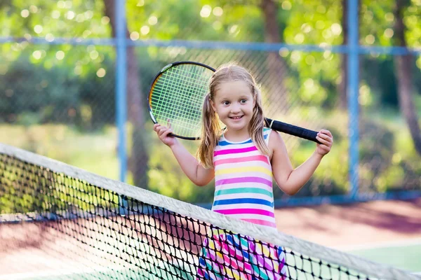 Ребенок, играя в теннис на открытом корте — стоковое фото