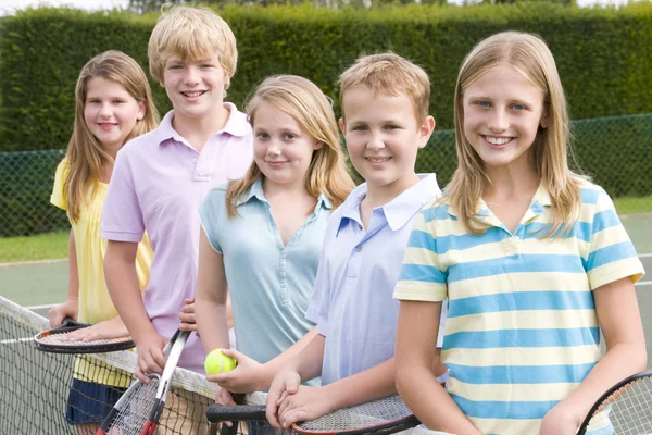Пять молодых друзей с ракетки на Теннисный корт улыбается — стоковое фото