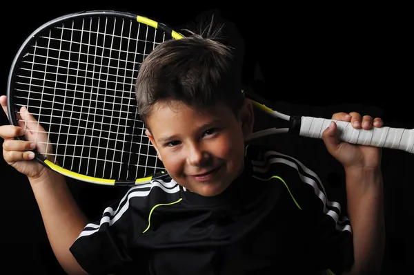 Теннис мальчик улыбается изолированы в черный — стоковое фото