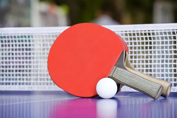 Два Настольный теннис или настольный теннис ракетки и мячи на синий таблицы — стоковое фото